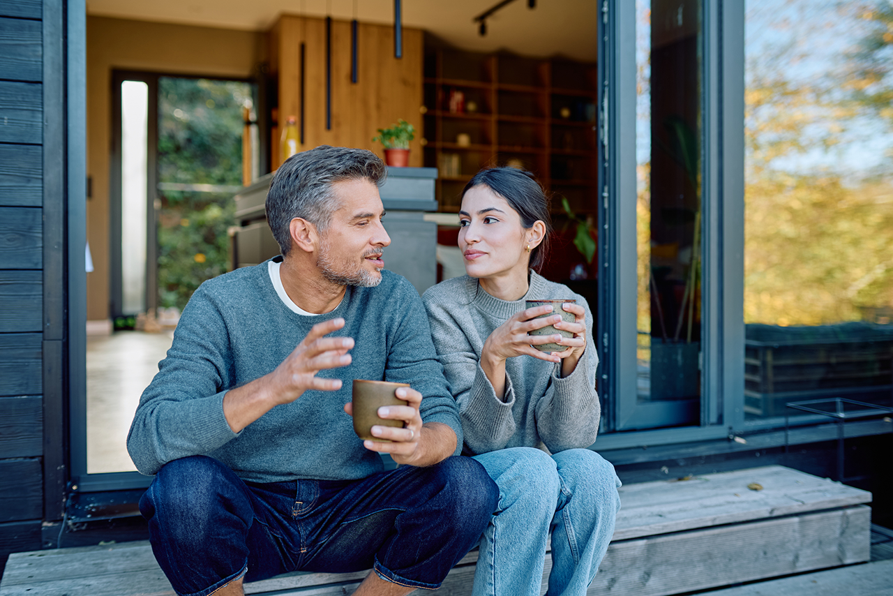 Couple relaxing and enjoying coffee while talking outdoors stock photo
